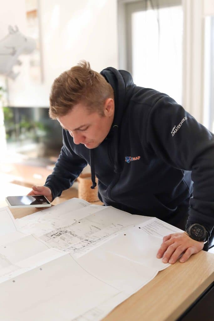 Homemap ilmanvaihto huollon ammattilainen valmistautuu ilmanvaihdon puhdistukseen tutkimalla talon iv-papereita